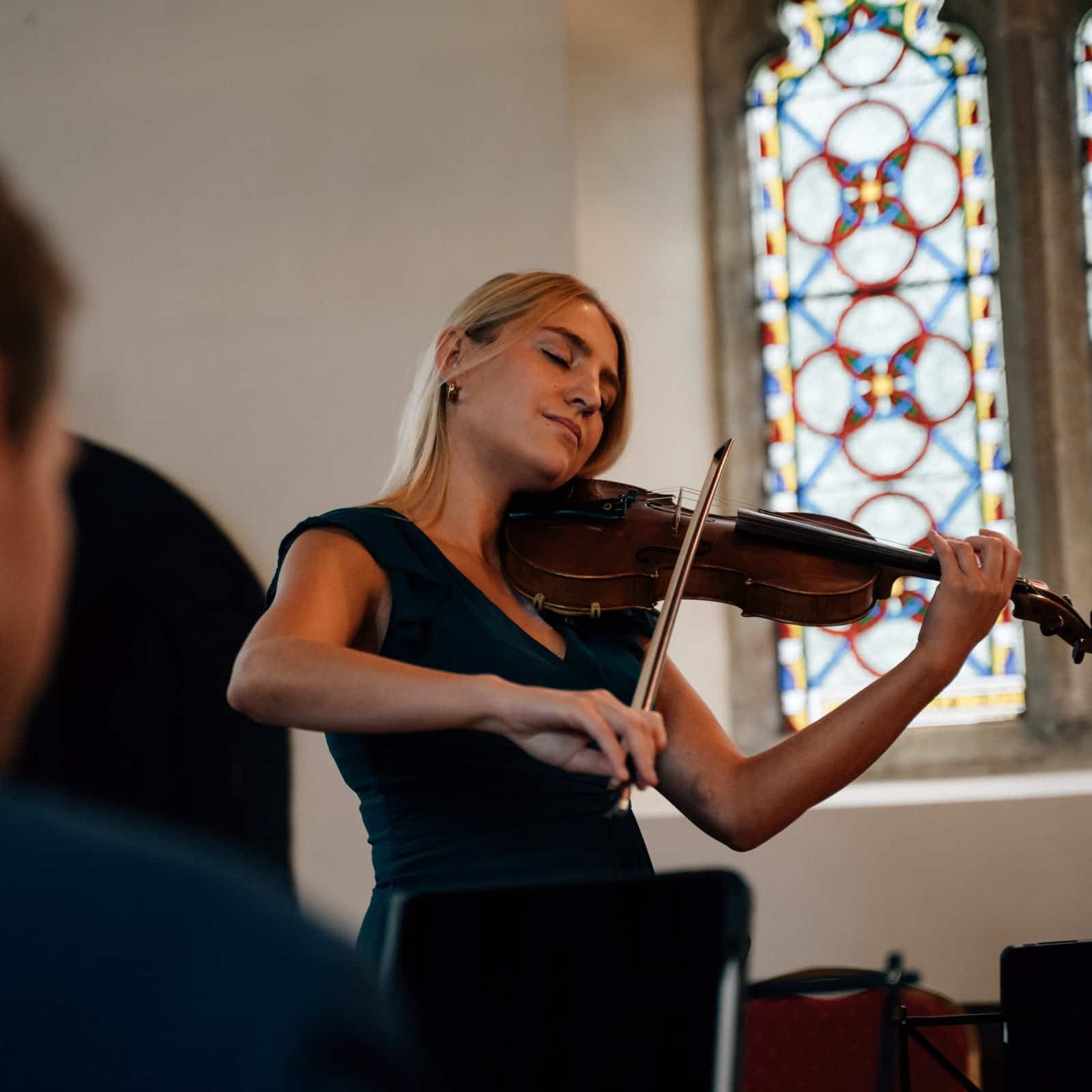 Lyra playing the violin in a church